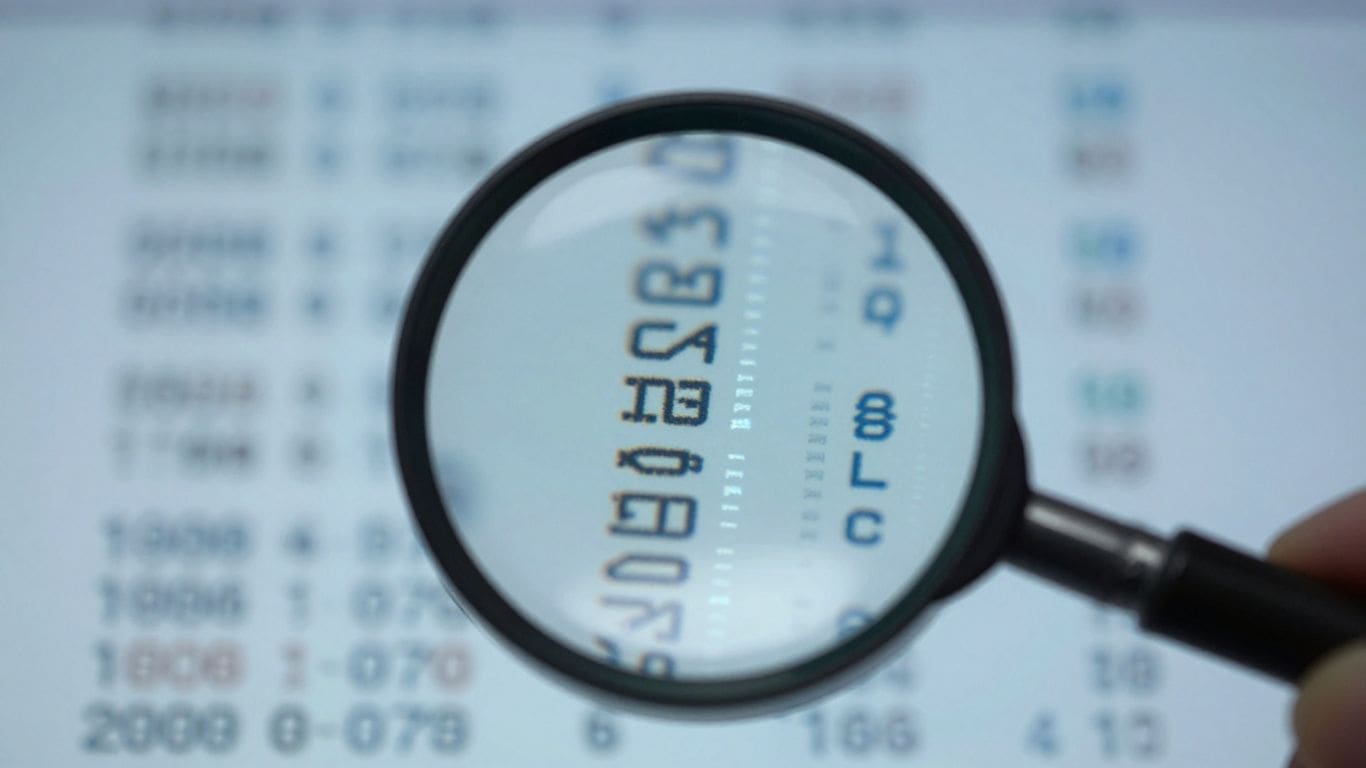 Magnifying glass over blurred numbers on a screen